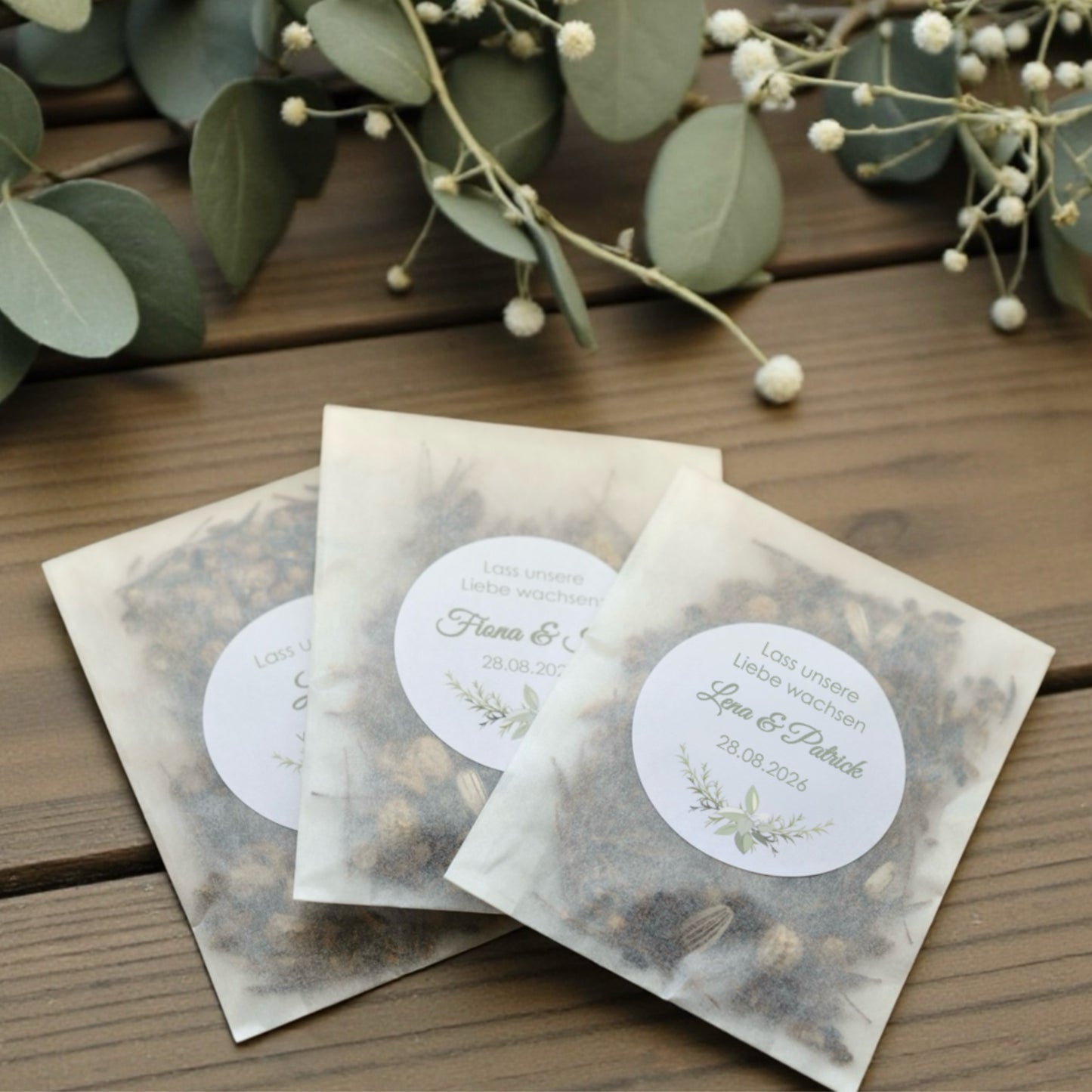 Personalisierte Blumensamen als nachhaltiges Gastgeschenk zur Hochzeit in Saatgut-Tütchen auf Holztisch