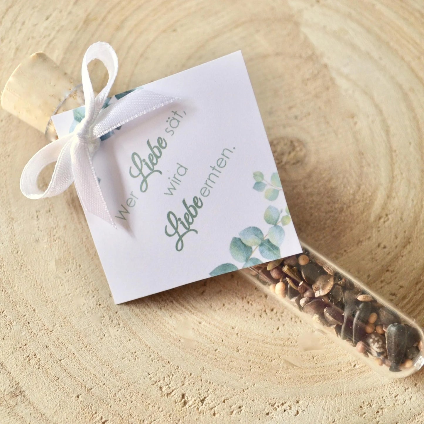 Gastgeschenk Blumensamen mit Anhänger und Aufschrift Wer Liebe sät, wird Liebe ernten
